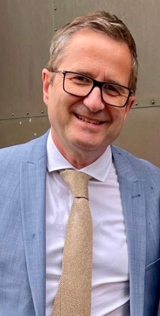 Dr. Hans-Ulrich Goos im hellblauen Anzug